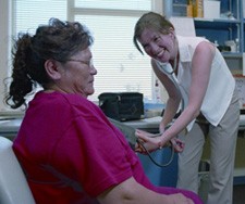 A nurse taking the blood pressure of a woman