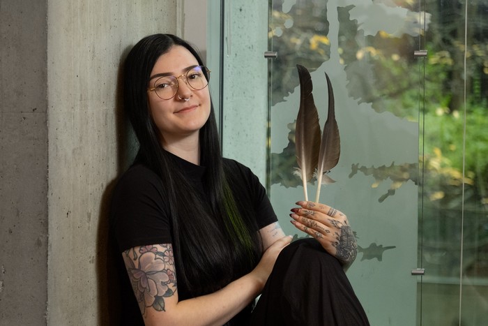 Isabelle (Izzy) Foy tenant 2 grandes plumes dans sa main