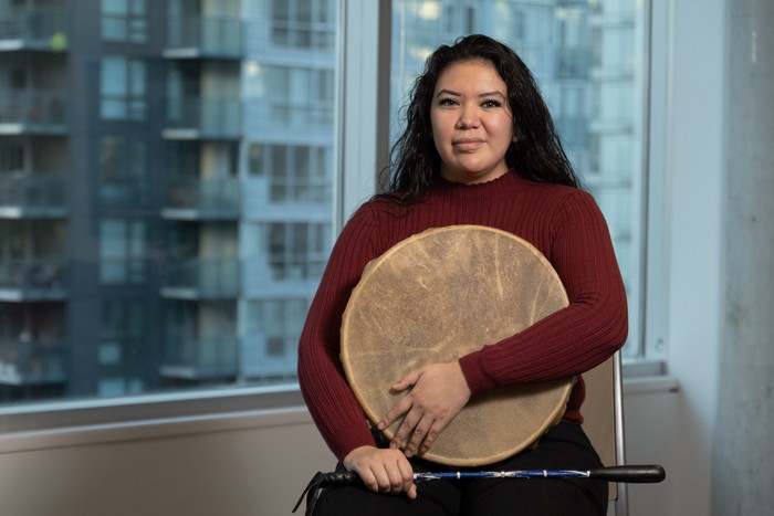 Jessica Hamilton tenant un tambour traditionnel et une baguette de tambour